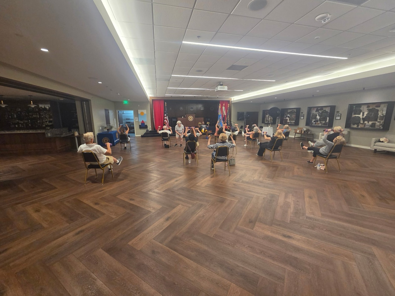 Wide view of a senior fitness class training with dumbbells